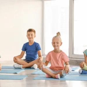Kind streckt sich auf der Yogamatte und lacht dabei